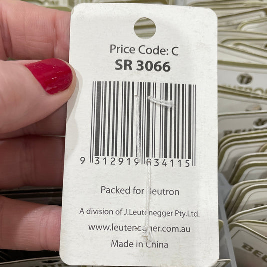 Close-up of a tag with a barcode held by a hand, with more tags in the background.