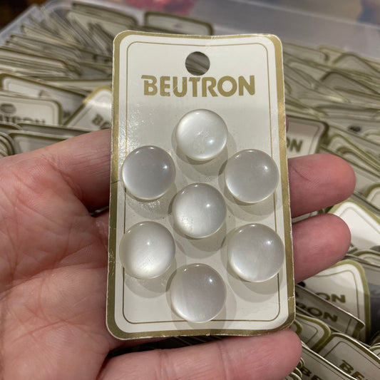 Hand holding a Beutron blister pack with white capsules against a blurred background