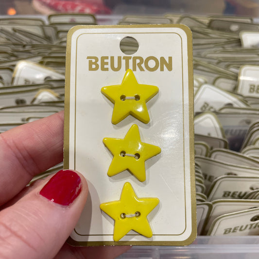 Three yellow star-shaped buttons on a BEUTRON card held by a hand.