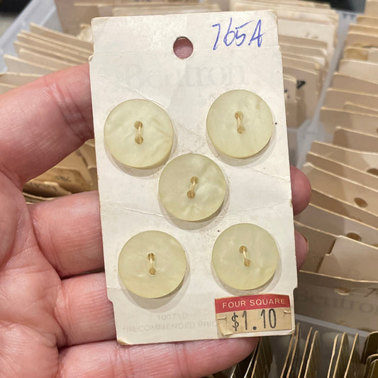 Hand holding a card with buttons in front of a collection of similar cards.