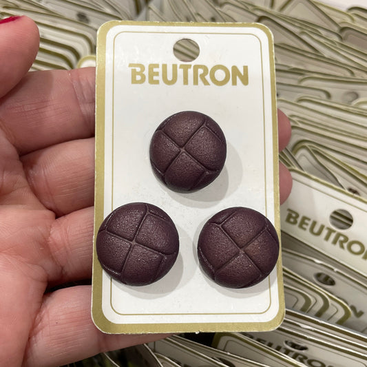 Hand holding a card with three chocolate-like buttons and 'BEUTRON' branding.
