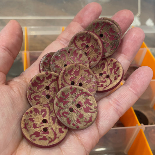 Hand holding decorative buttons with a blurred background