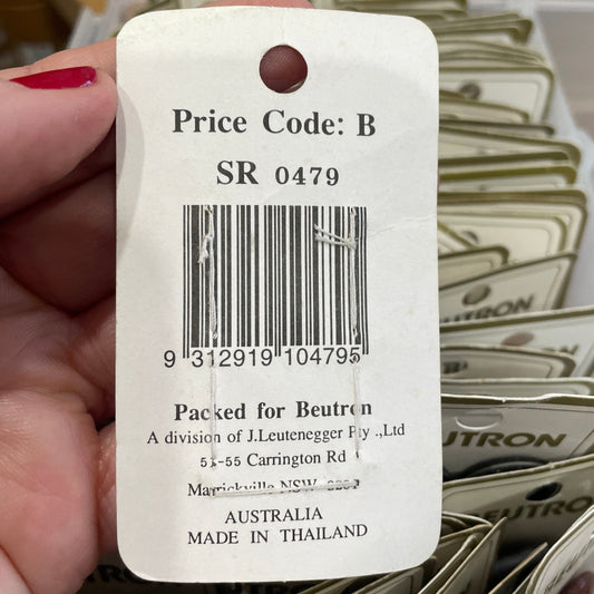 Hand holding a price tag with a barcode and text, surrounded by similar tags.
