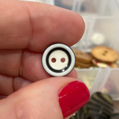Small round button held between fingers with a blurred background