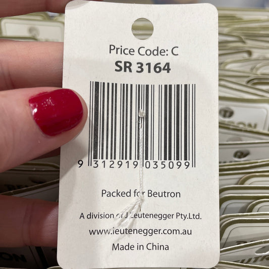 Close-up of a product tag with a barcode held by a hand.