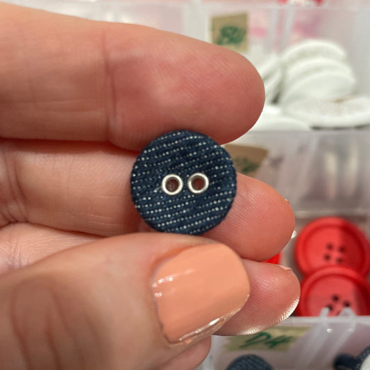 Hand holding a blue button with a background of various buttons