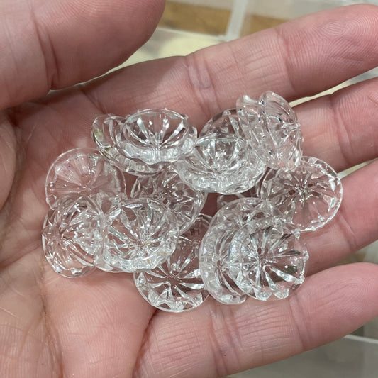 Hand holding clear decorative stones with a transparent container in the background