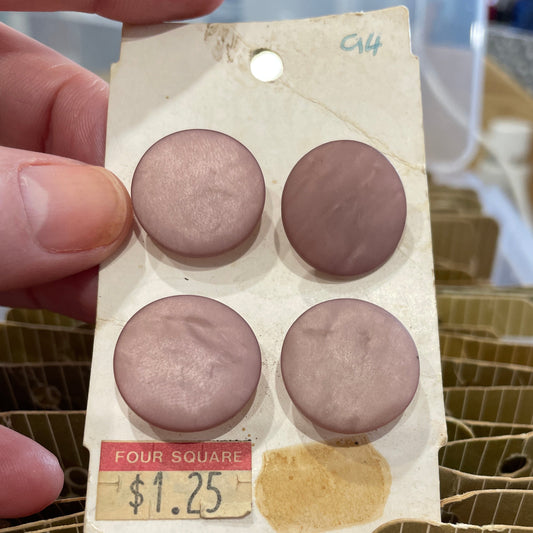 Close-up of a small package with four round buttons on a blurred background