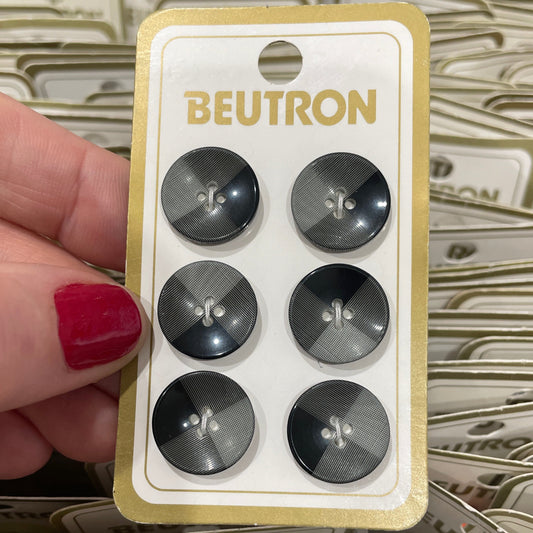 Packaged buttons with 'Beutron' branding held by a hand.