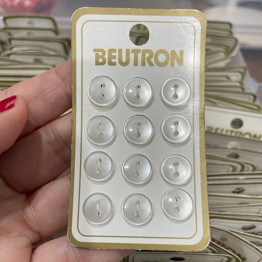 Pack of buttons with 'Beutron' branding held by a hand.