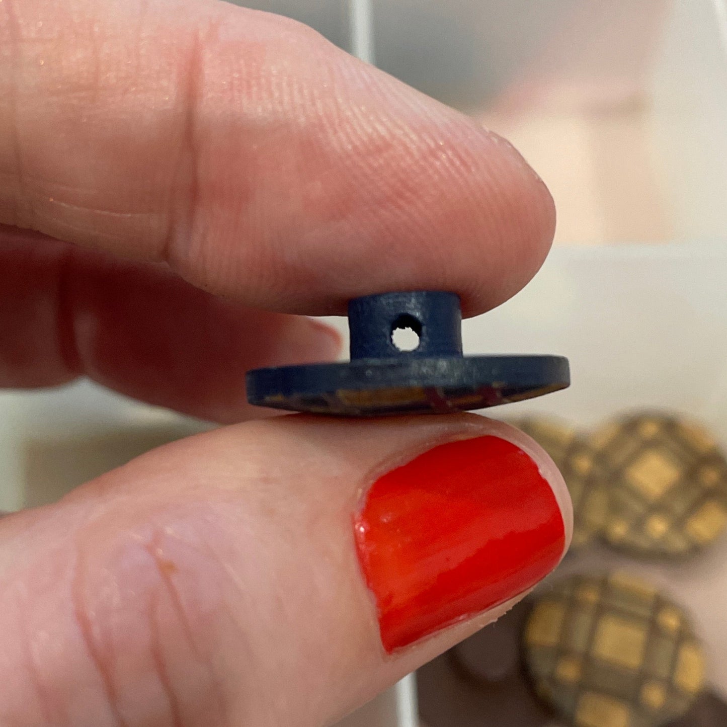 Hand holding a blue button with a grid of buttons in the background
