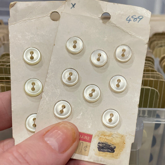 Hand holding a card with buttons against a blurred background