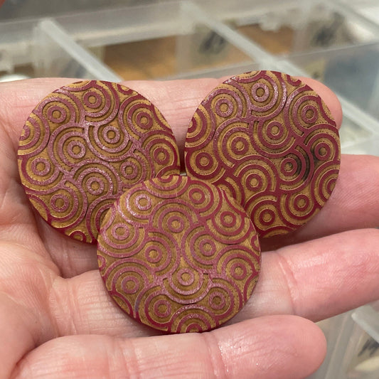 Hand holding decorative wooden buttons with a container of assorted buttons in the background