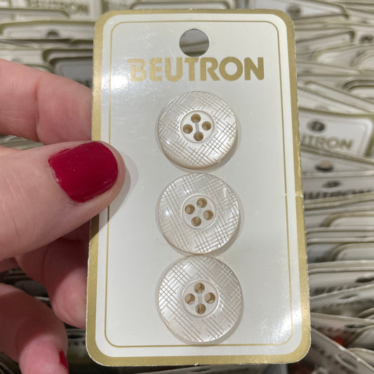 Three buttons on a Neutron card held by a hand with red nail polish.