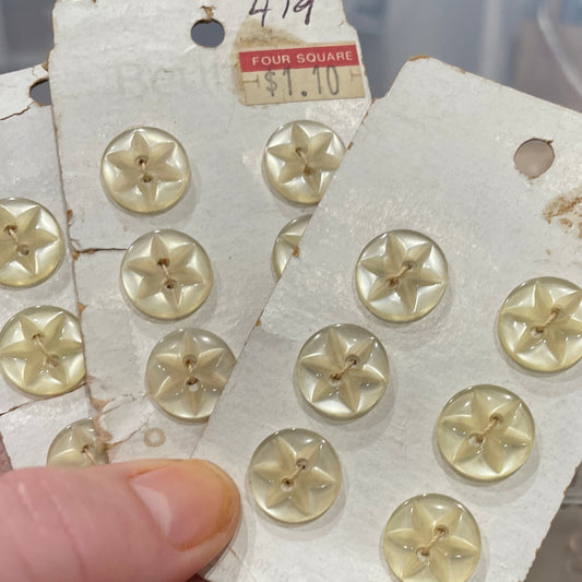Hand holding a card with gold buttons on a blurred background