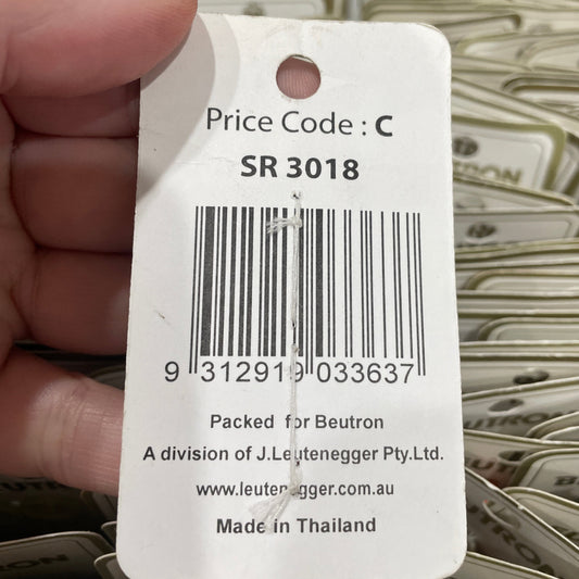 Close-up of a price tag with a barcode held by a hand, with a blurred background of similar tags.