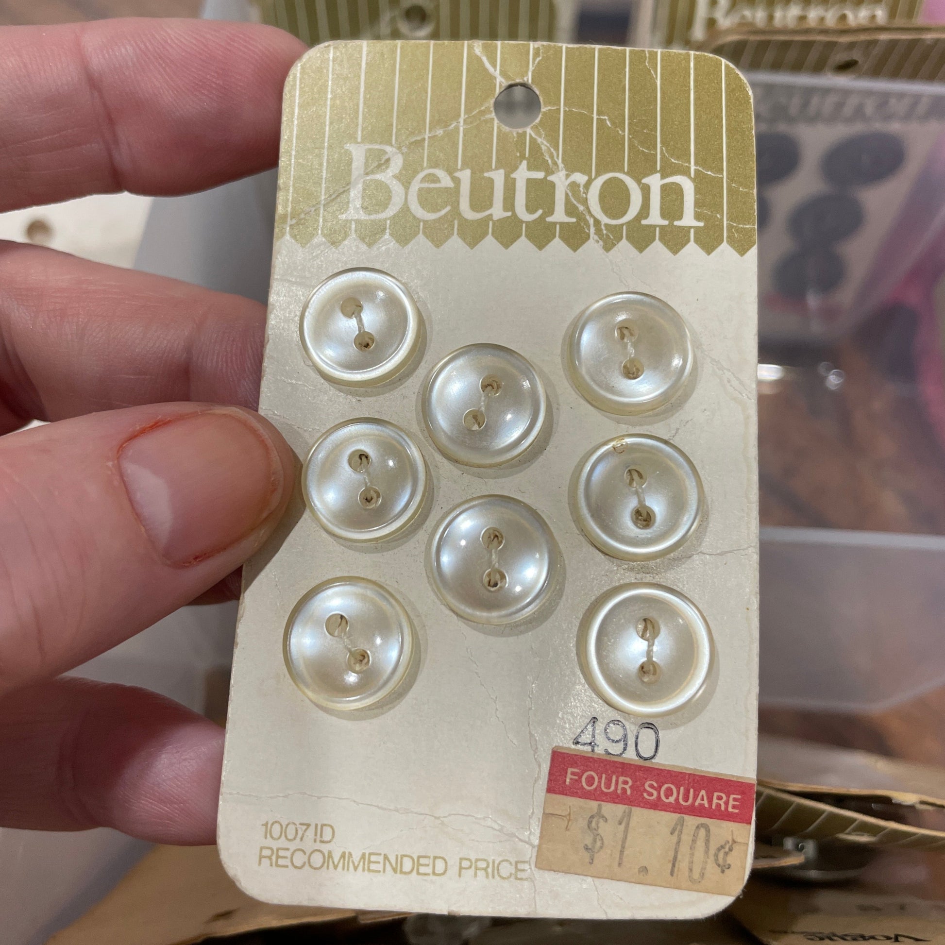 Buttons on a card held by a hand with a blurred background