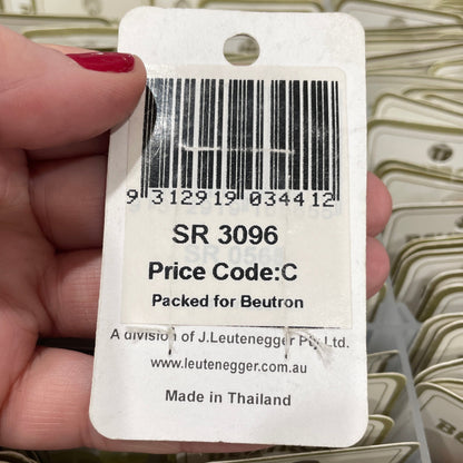 Hand holding a product tag with a barcode and text, surrounded by more tags.