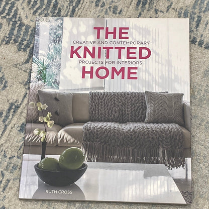Book titled 'The Knitted Home' on a textured surface