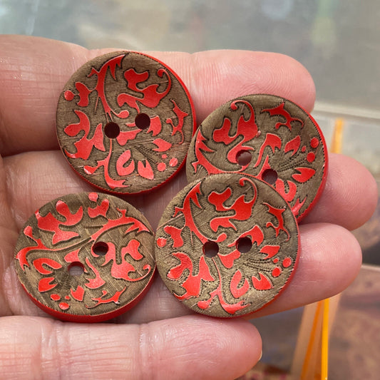 Hand holding decorative buttons with a container of buttons in the background