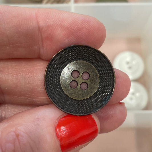 Hand holding a black button with a white background showing various buttons
