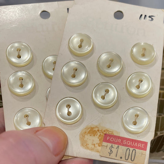 Hand holding a card with white buttons and a price tag, with a blurred background.
