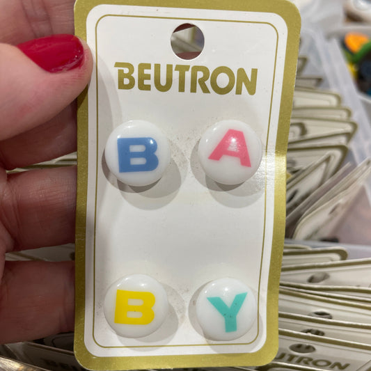 Packaged baby buttons with 'Beutron' branding held by a hand.