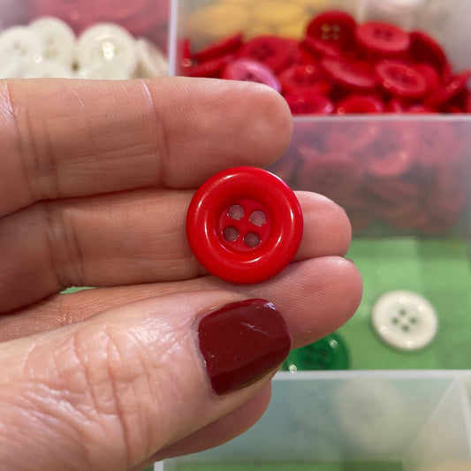 Hand holding a red button with a background of color-coded button drawers.