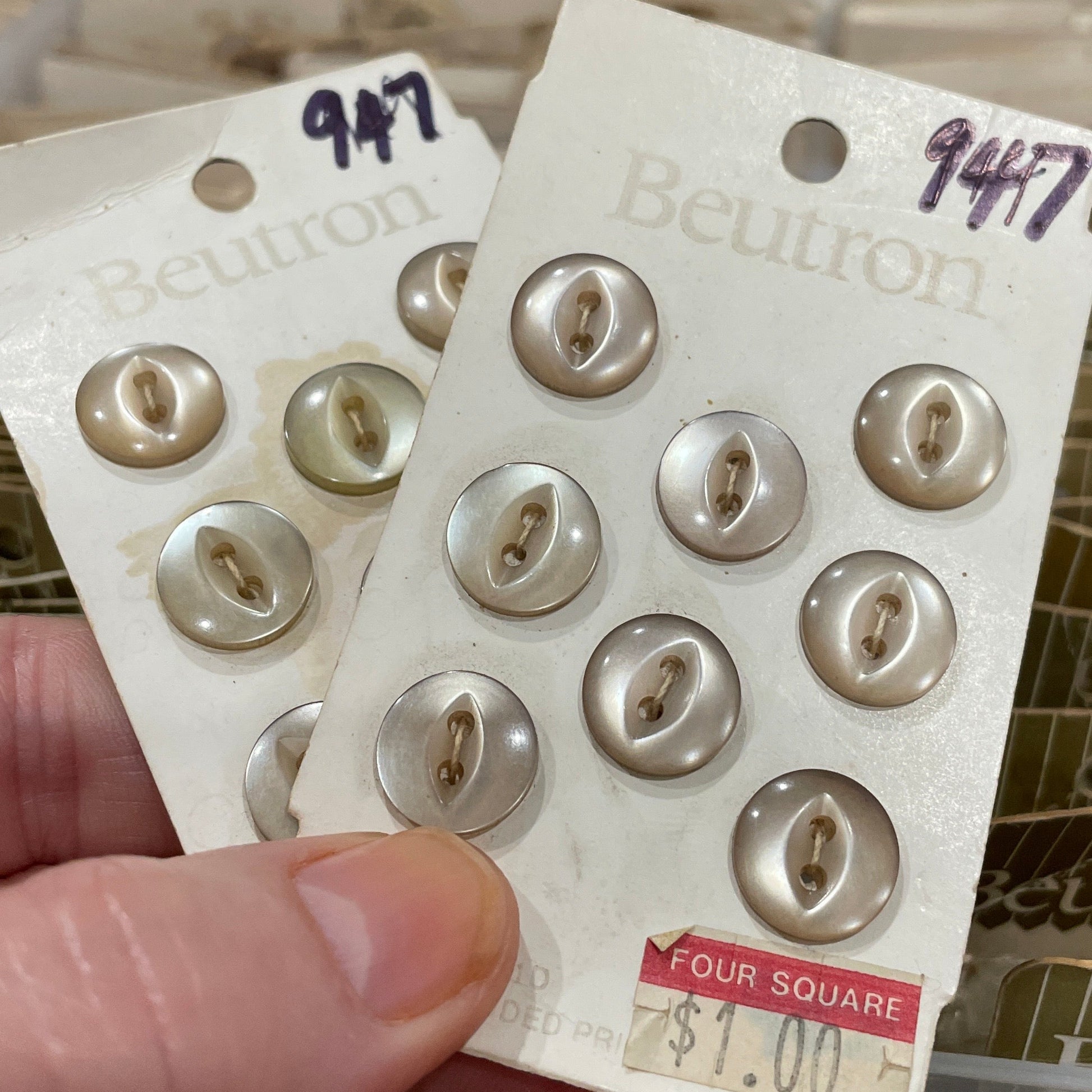 Packaging of buttons with a visible brand label held by a hand.