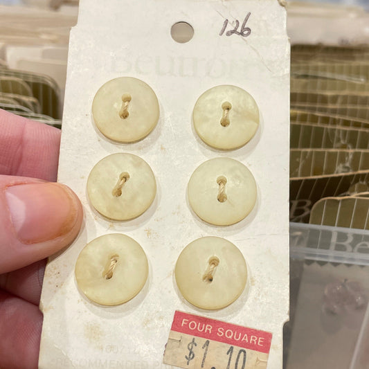 Set of vintage buttons on a card held by a hand with a blurred background