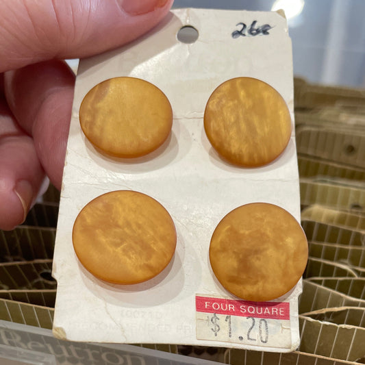 Hand holding a small card with four buttons next to a clear plastic container