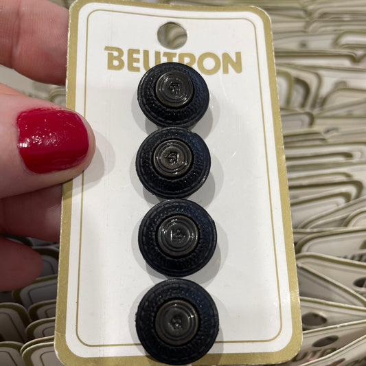 Four black buttons on a Beltron branded card held by a hand with red nail polish.