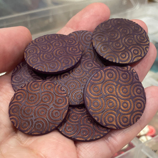 Hand holding buttons with a blurred background of a storage container with various items.