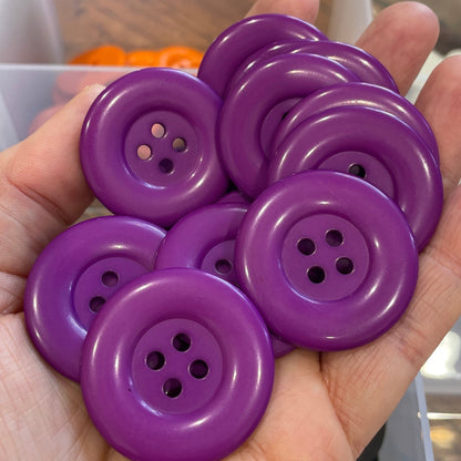 Hand holding purple buttons with a blurred background