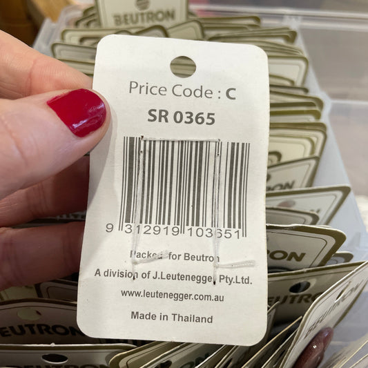 Close-up of a price tag with a barcode held by a hand.