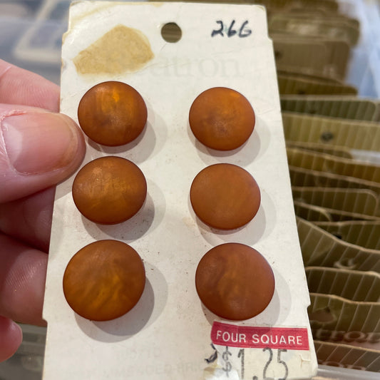Set of buttons on a card held by a hand with a blurred background