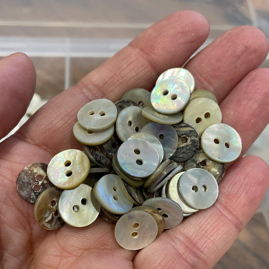 Hand holding a collection of buttons with a blurred background