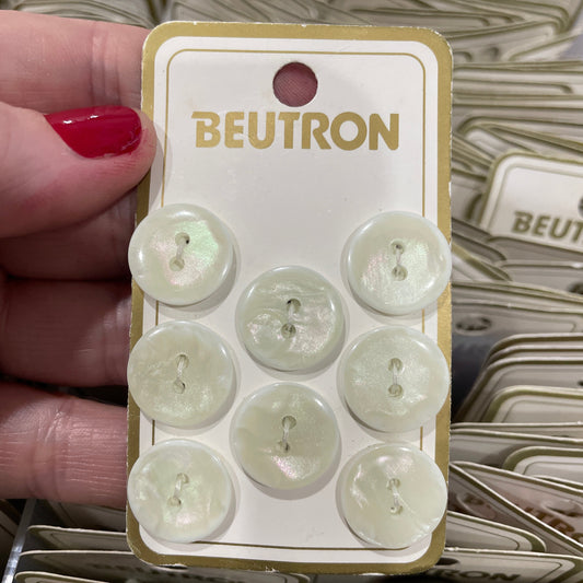 Pack of buttons with a 'Beutron' label held by a hand.