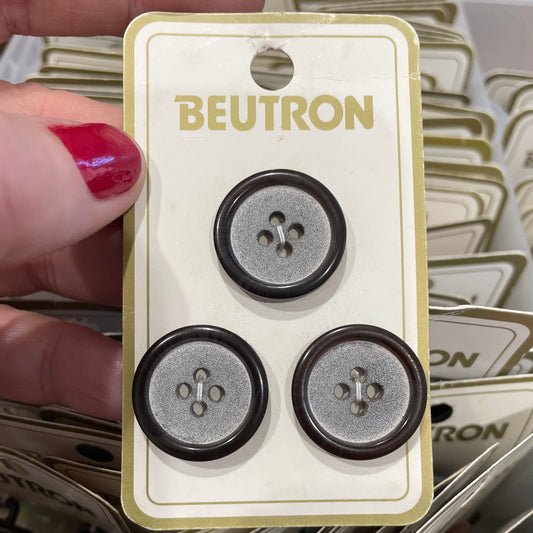 Beutron button packaging with three buttons on a card held by a hand.