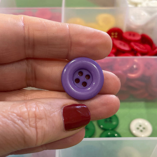 Hand holding a purple button with a background of colorful buttons in containers