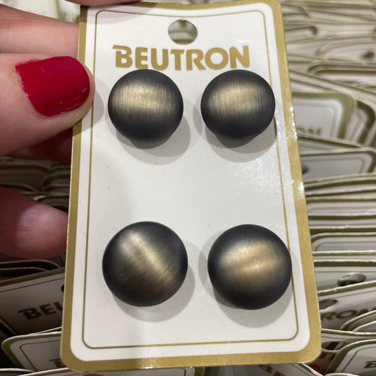 Four buttons  on a Beutron branded card held by a hand with red nail polish.