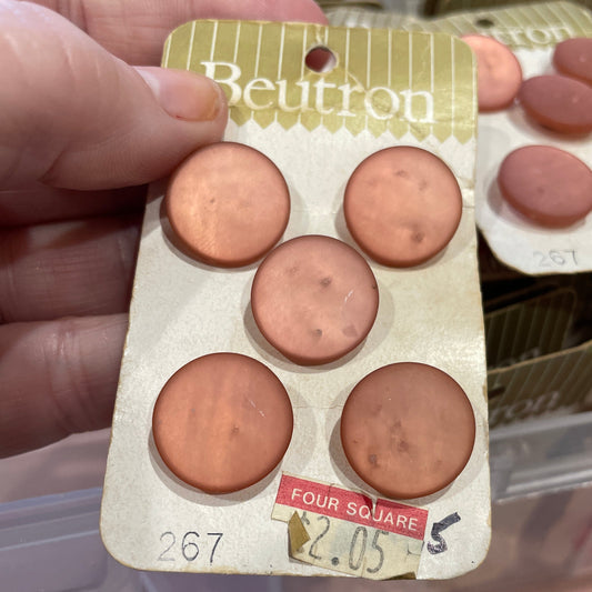 Buttons held by a hand, with blurred background