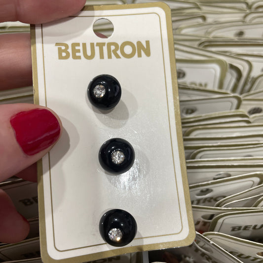 Black buttons on a BEUTRON branded card held by a hand with red nail polish.