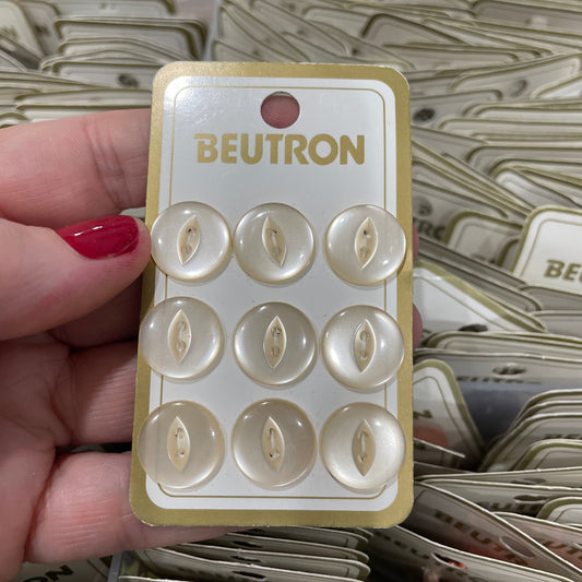 Beutron buttons on a card held by a hand with red nail polish.