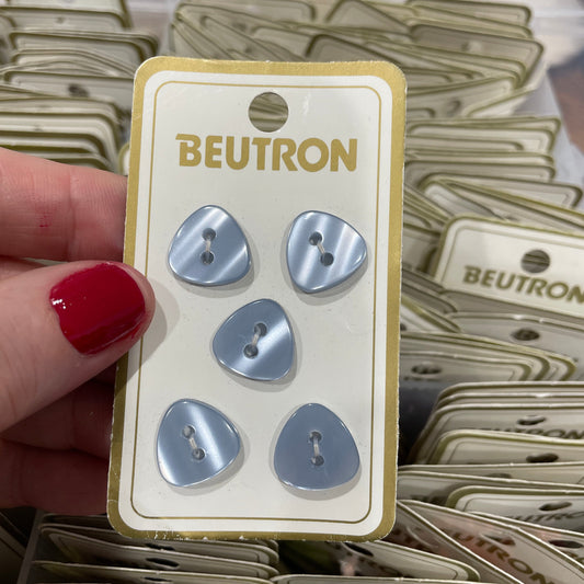 Packaging of buttons with 'Beutron' branding held by a hand.