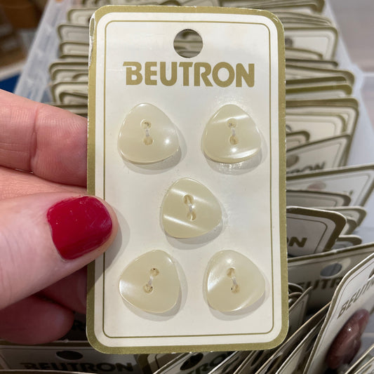 Beutron buttons on a card held by a hand with red nail polish, surrounded by more buttons.