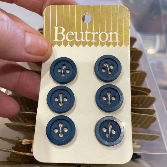 Card with blue buttons held by a hand, with a blurred background
