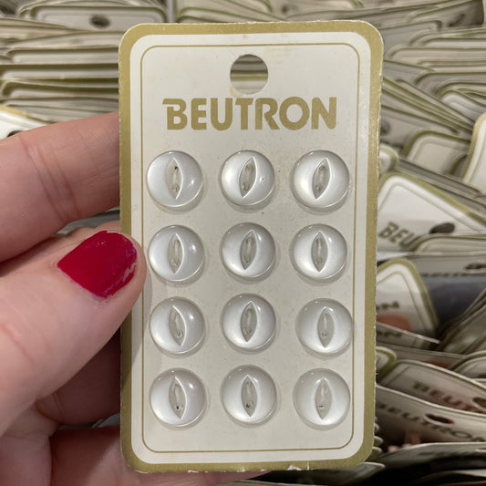 Hand holding a Beutron product packaging with red nail polish.