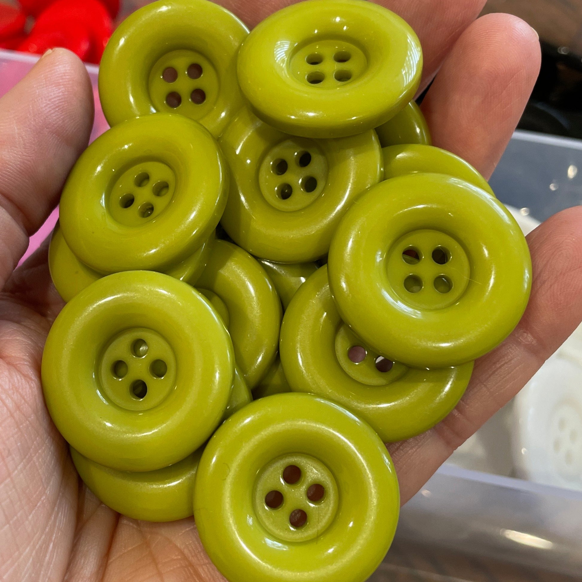Hand holding a cluster of green buttons with a blurred background