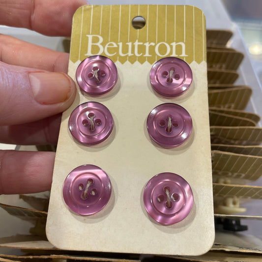 Hand holding a card with pink buttons and 'Beutron' branding.